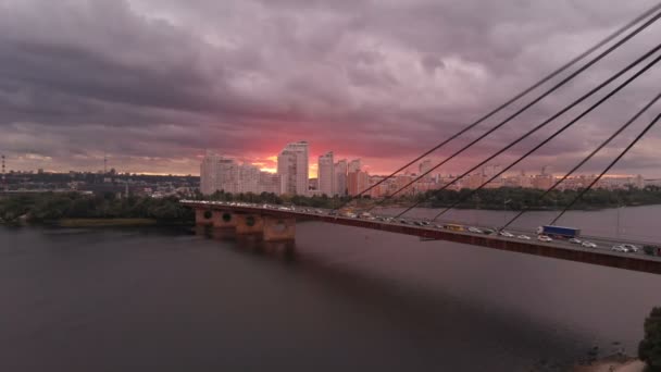 Современный автомобильный мост через Днепр летом на многоцветном закате — стоковое видео