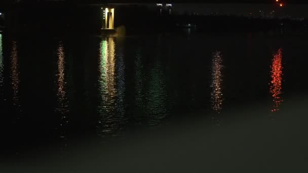 Camera record surface of night river and than up to the bridge in led light. — Stock Video