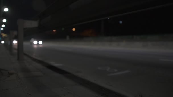 Samochody poruszają się po nocnej drodze-niski kąt widzenia. — Wideo stockowe