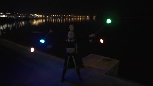 Två tallledda konstnär gör tricks med LED POI på natten nära floden. — Stockvideo