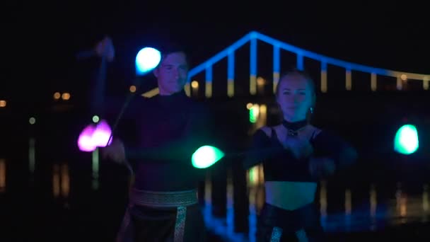 Retrato de dos artistas hombre y mujer en trajes negros que giran la piscina led — Vídeos de Stock