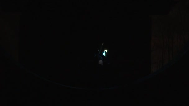 Одна девушка крутит диодный пои под мостом ночью в замедленной съемке . — стоковое видео