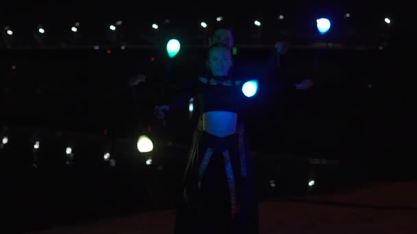 Circus artists man and woman in black suits that spin the led poi — Stock Video
