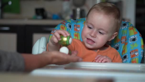 Carino piccolo bambino con uovo di Pasqua bussare con un'altra mano con uovo di Pasqua — Video Stock