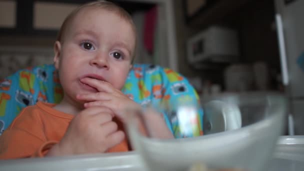 Grappige actie met baby die eet in slow motion op de keuken. — Stockvideo