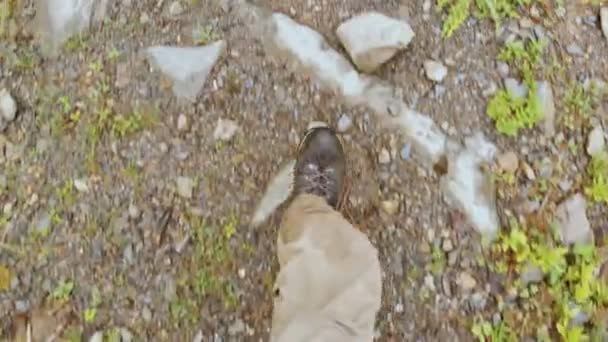 Pov view of the legs with hiking boots of the man that walking on the hill . — стоковое видео