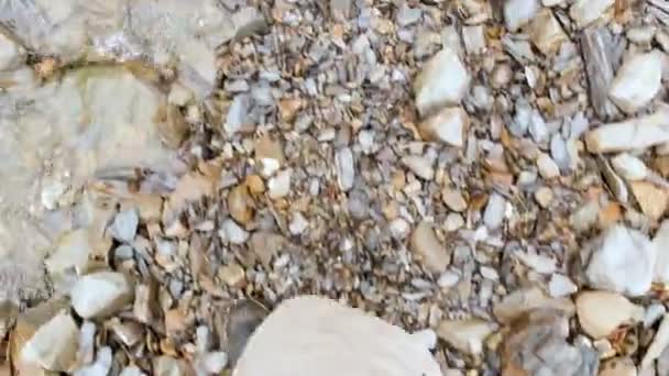 POV pohled na nohy s rozhárýma botama muže, který chodí po vodě — Stock video