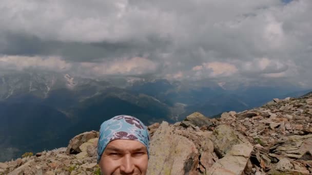 Muž bere kameru do ruky na horu a ukazuje jazyk — Stock video