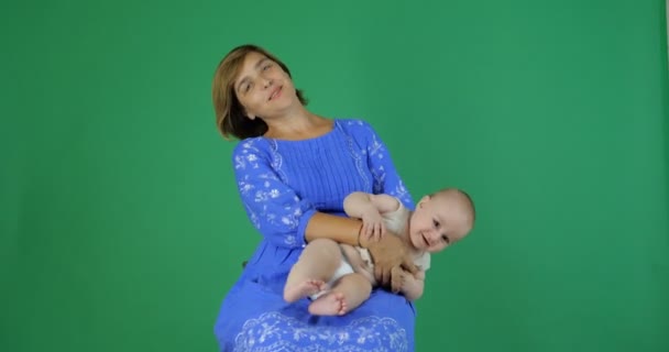 4K - Mom cheerfully moves charming toddler while sitting, slow motion, chromakey — Stock Video