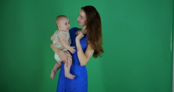 Jovem morena mulher toca babys nariz e ele sorri, câmera lenta, chromakey — Vídeo de Stock