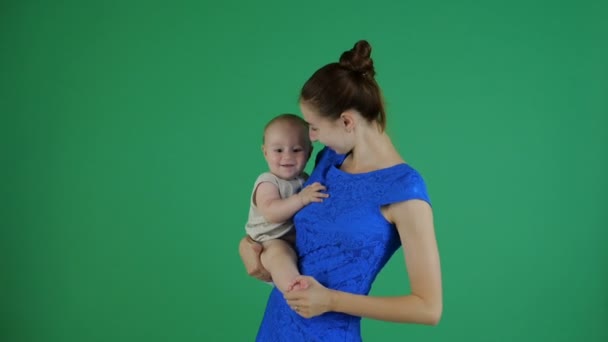 4K-μια νεαρή μητέρα κάνει ασκήσεις για ένα μικρό χαμογελαστή μωρό, υψώντας το πόδι του — Αρχείο Βίντεο
