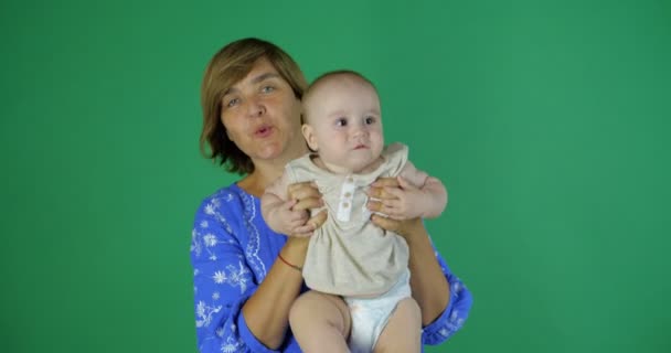 Jeu mignon de femme âgée avec 1 an d'enfant en studio sur l'écran vert . — Video