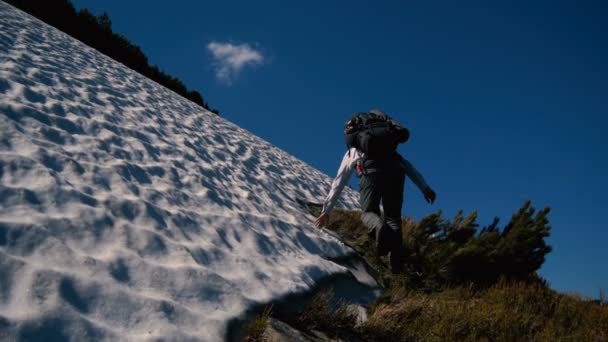 Dappere toerist klimmen een berg met sneeuw in de Karpaten in slo-mo — Stockvideo