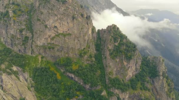 4K-powietrzne zbliżanie się do wysokich skalistych gór, w chmurach na Kaukazie — Wideo stockowe