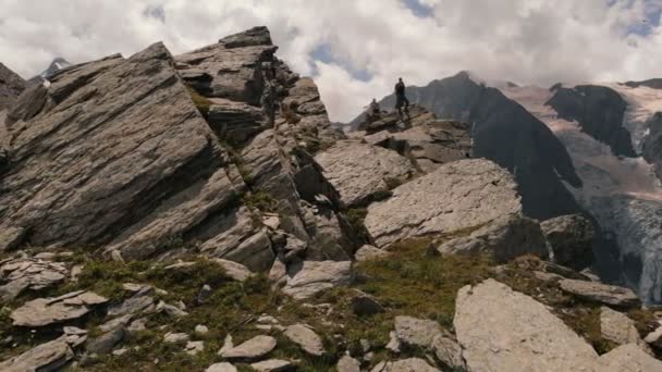 4k - Spedizione sulla cima di un'alta montagna rocciosa, cielo nuvoloso, azione aerea — Video Stock