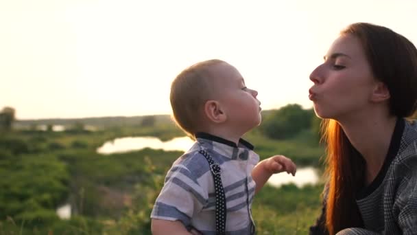 Mamma kysser barnet i svampen, han sträcker sig till henne utomhus i slow motion — Stockvideo