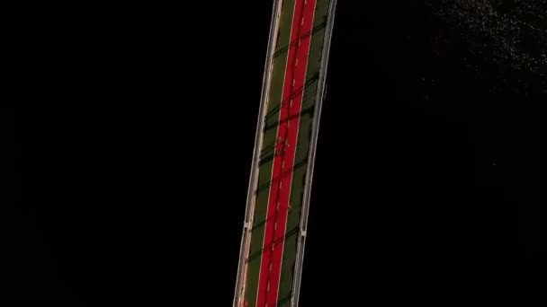 Воздух весёлых людей, делающих фигурку цветка с дроном, переворачивающимся через мост — стоковое видео