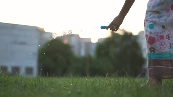 Zeepbellen, gemaakt door een jong meisje, vliegen prachtig op groen gras — Stockvideo