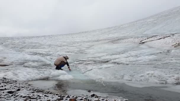 Crystal Whirlpool kör i snöiga berg och turister tar vatten i slo-mo — Stockvideo