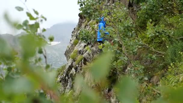 Turista femenina escalando una ladera vertical en las montañas georgianas en slo-mo — Vídeos de Stock