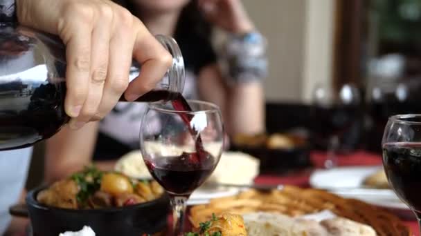 Šťastní turisté v létě popíjejí červené víno v gruzínských horách — Stock video