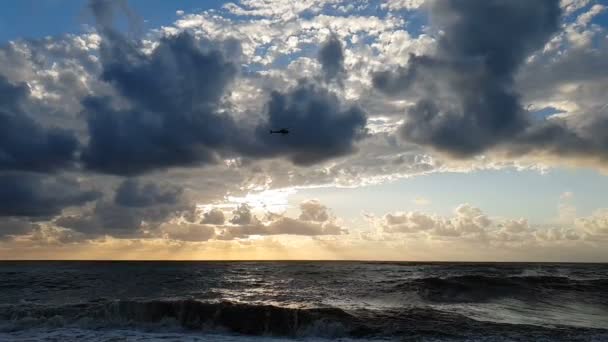 Helicóptero voando sobre a praia tempestuosa em um dia nublado no verão em slo-mo — Vídeo de Stock