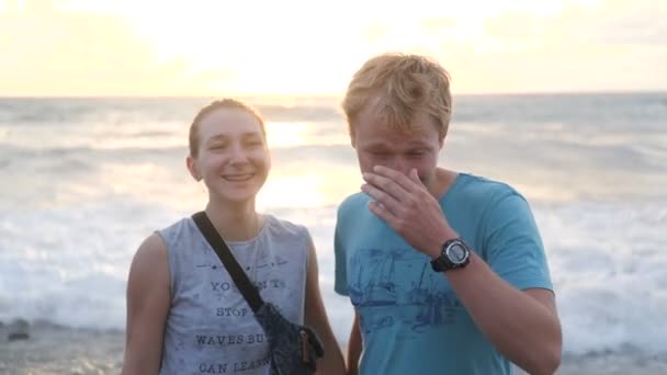 Счастливая пара смеется и стоит на берегу моря в Грузии в сло-мо — стоковое видео