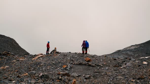 Tres jóvenes escaladores mirando a su alrededor en la cima de una montaña en Georgia en slo-mo — Vídeo de stock