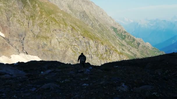 Touriste en uniforme va à travers la vallée avec des pierres dans les montagnes géorgiennes — Video