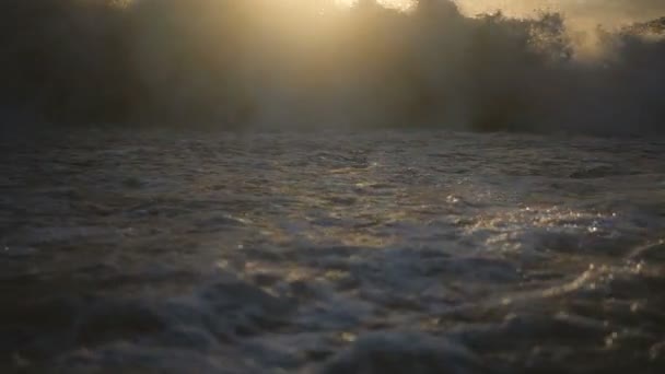 Das raue schwarze Meer mit dunklen Steinen bei heftigem Sonnenuntergang im Sommer in Zeitlupe. — Stockvideo