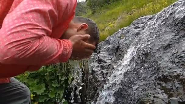Giovane uomo che si lava la faccia in un torrente di montagna che scorre in Georgia a Slo-mo — Video Stock