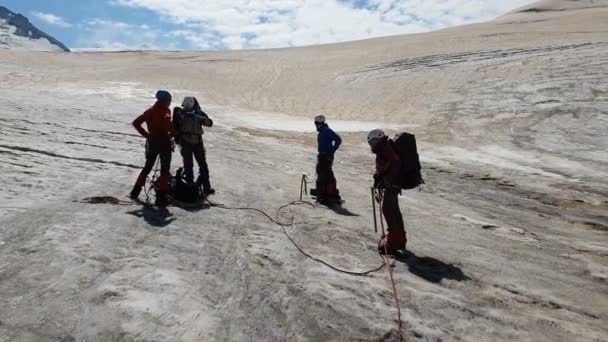 Cuatro escaladores de pie con hachas de hielo en las montañas de Georia en verano en slo-mo — Vídeos de Stock