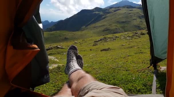 Kaki laki-laki di kaus kaki bergerak ceria di tenda dimasukkan ke dalam lembah hijau — Stok Video