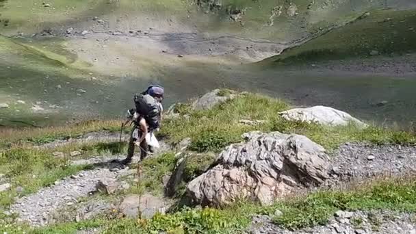 Escaladora trekking en una empinada ladera de una montaña en verano en slo-mo — Vídeos de Stock