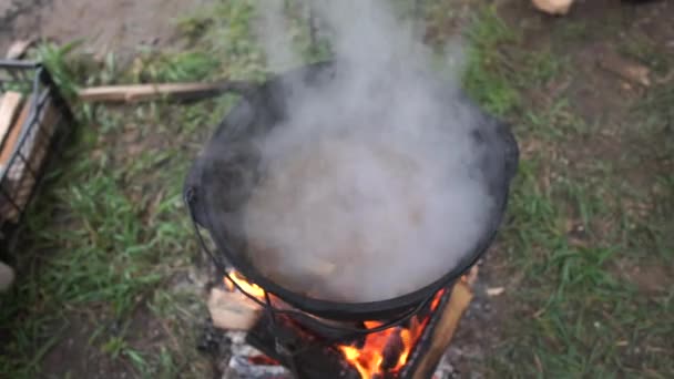 Trozos de carne rebanados hirviendo en una olla grande con sopa al aire libre en slo-mo — Vídeos de Stock