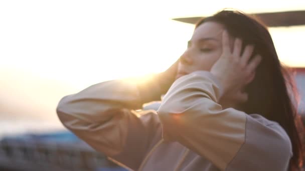 Молодая брюнетка делает массаж головы и волос на солнце в замедленной съемке — стоковое видео