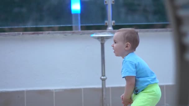 Um menino bonito pequeno bate fora de uma bola inflável como um jogador de voleibol em câmera lenta — Vídeo de Stock