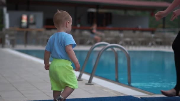 Het kind gaat naar het zwembad en vertrekt voorzichtig in slow motion — Stockvideo