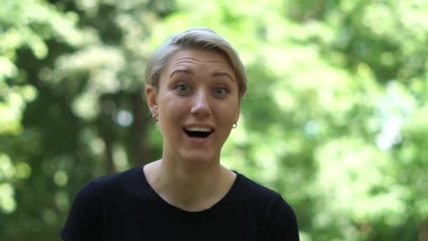Zabawna blond kobieta stoi i podnoszenie jej rękę z niespodzianką w lecie w SLO-mo — Wideo stockowe
