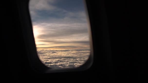 Blick in den Morgenhimmel mit Wolken durch das Bullauge des Flugzeugs — Stockvideo