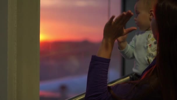 Молодая девушка путешественник со своим маленьким сыном стоять у окна аэропорта, замедленная съемка — стоковое видео