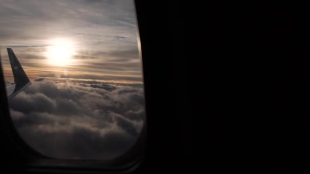 Atemberaubender Blick auf die Wolken durch das Bullauge des Flugzeugs in Zeitlupe — Stockvideo