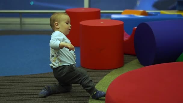 Lindo chico alegremente corre en la zona de juegos para niños en el aeropuerto en cámara lenta — Vídeo de stock