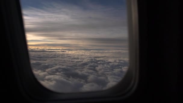 El cielo con nubes al amanecer a través del ojo de buey del avión en cámara lenta — Vídeos de Stock