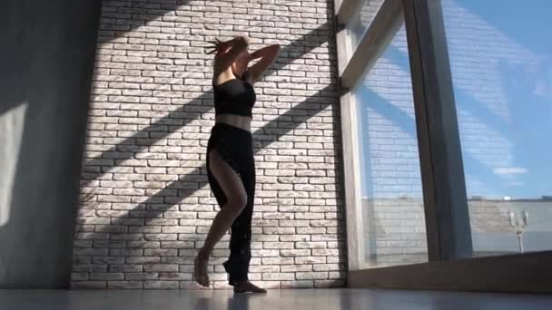 Духовная блондинка, стоящая и танцующая, поднимая руки в студии — стоковое видео