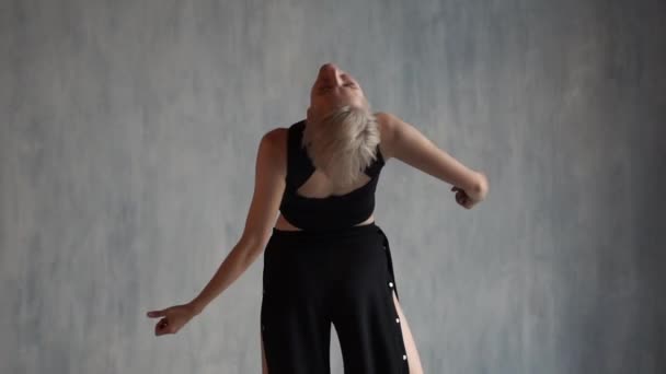 Slim Blond flicka spinning och dansa som en ballerinain en studio i slo-mo — Stockvideo