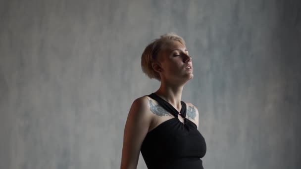 Арти-блондинка-балерина, стоящая и изгибающаяся под бременем жизни в студии в сло-мо — стоковое видео