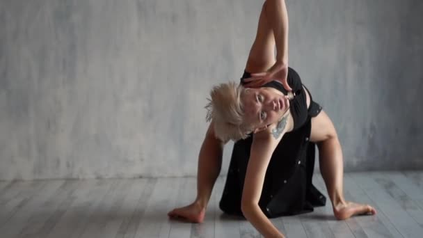Indrukwekkende blonde ballerina liggend en Rolling tijdens het dansen overweegt in een studio in slo-mo — Stockvideo