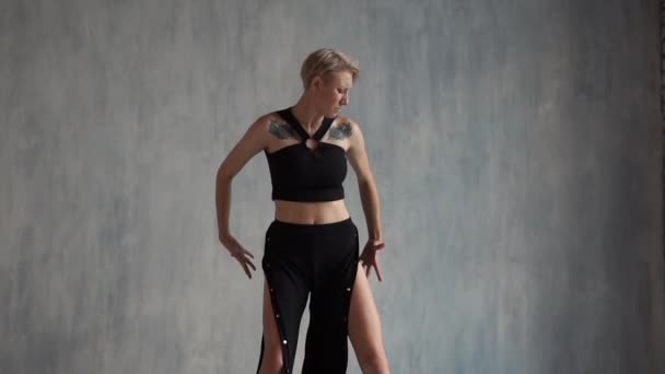 Etkileyici sarışın kız bacaklarını sallayarak ve slo-mo bir stüdyoda bir bayan savaşçı gibi dans — Stok video