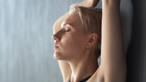 Prachtig meisje staande op een muur en het verhogen van haar handen terwijl dansen in een studio in slo-mo — Stockvideo